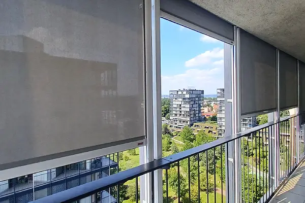 pohled přes staženou screenovou roletu na balkóně